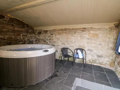 a sauna with two chairs and a hot tub at Leghorn in St Austell