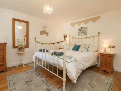 a bedroom with a bed and a dresser and a mirror at Courtyard in Porthleven