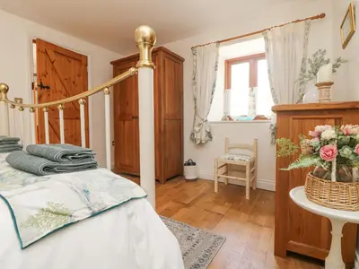 a bedroom with a bed and a table with flowers at Courtyard in Porthleven
