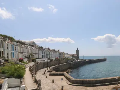 a row of houses on a street next to the ocean at Courtyard in Porthleven