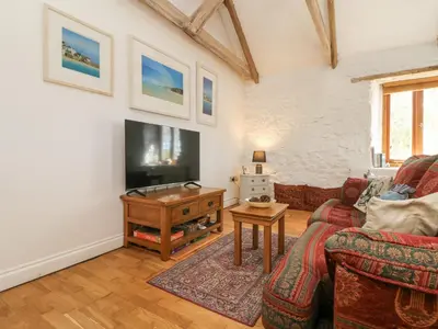 a living room with a couch and a flat screen tv at Courtyard in Porthleven