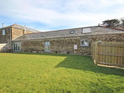 a brick house with a fence and a yard at The Old Dairy in Padstow