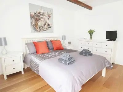 a bedroom with a bed with two towels on it at The Old Dairy in Padstow