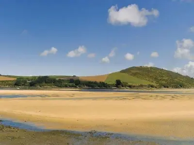 a view of a beach with a hill in the background at The Old Dairy in Padstow