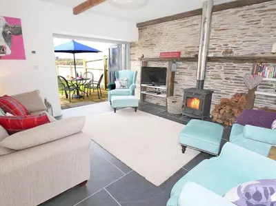 a living room with a couch and chairs and a fireplace at The Old Dairy in Padstow