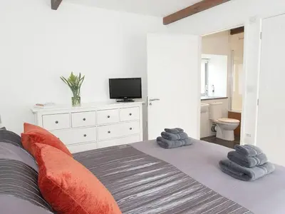 a bedroom with a bed with towels on it at The Old Dairy in Padstow