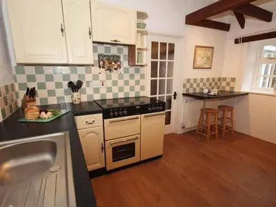 a kitchen with a sink and a stove top oven at Dairy Cottage in Bodmin