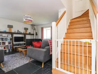 a living room with a staircase and a couch at Sundowner in Padstow