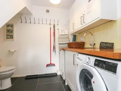 a laundry room with a washer and dryer at Sundowner in Padstow