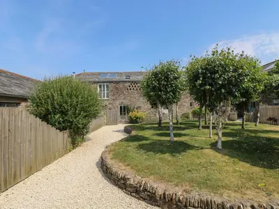 a house with trees in front of a fence at Sundowner in Padstow