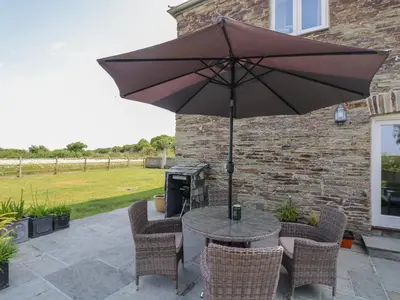 a table and chairs with an umbrella on a patio at Sundowner in Padstow