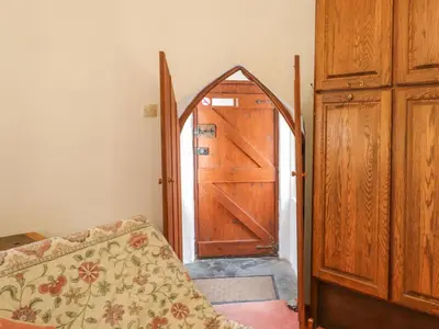 a wooden door in a room with a couch and a door at Millstream in Tintagel