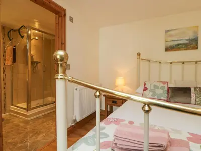 a bedroom with a bed and a walk in shower at Mill in Porthleven