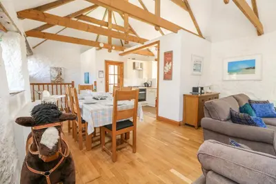 a dog sitting in a living room with a table at Mill in Porthleven
