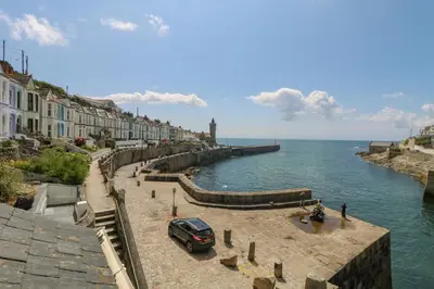 a car parked on a street next to the water at Mill in Porthleven