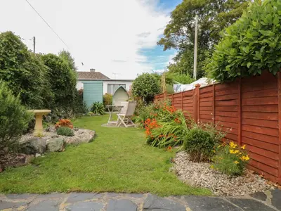 a garden with a fence and a table and chairs at Pippin in St Ives