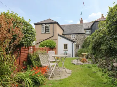 a garden with a table and chairs in front of a house at Pippin in St Ives