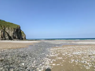 a beach with rocks and the ocean in the background at Ocean Blue in Porthtowan