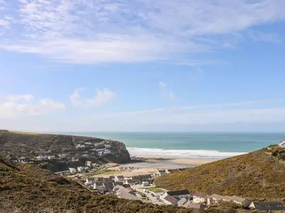 a view of a beach and the ocean from a hill at Ocean Blue in Porthtowan