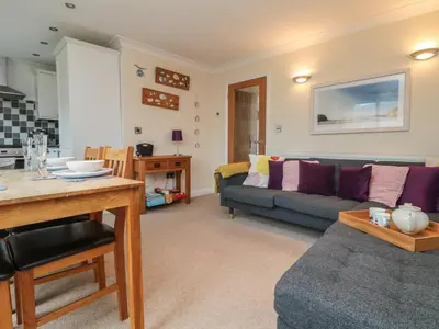 a living room with a couch and a table at Ocean Blue in Porthtowan