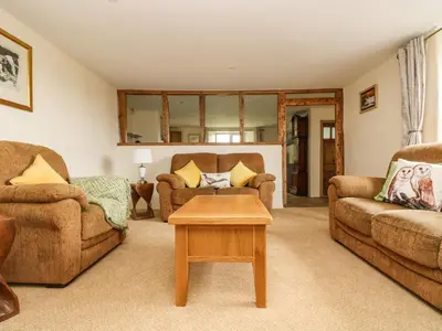 a living room with two couches and a table at Withan Farm Wing in Manaccan