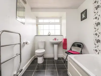a white bathroom with a toilet and a sink at Withan Farm Wing in Manaccan