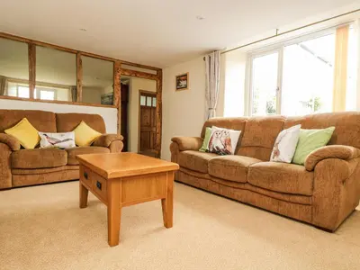 a living room with two couches and a coffee table at Withan Farm Wing in Manaccan