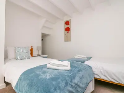 a bedroom with two beds with towels on top of it at The Barn in Gunwalloe