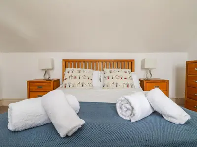 a bedroom with a bed with towels on the floor at Trelawns in Mawgan Porth