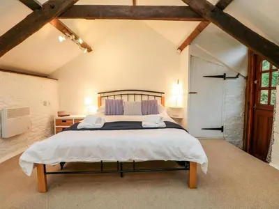 a bedroom with a large bed in a attic at Apple Loft in Lostwithiel