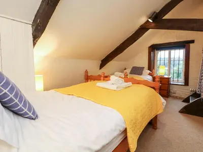 a bedroom with two beds and a window at Apple Loft in Lostwithiel