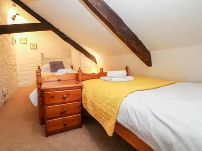 two twin beds in a attic bedroom with a dresser at Apple Loft in Lostwithiel