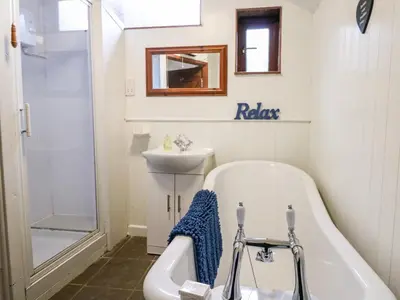 a bathroom with a tub and a sink at Apple Loft in Lostwithiel