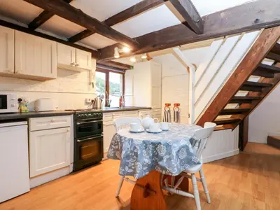 a kitchen with a table and chairs in a room at Apple Loft in Lostwithiel