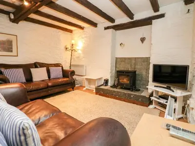 a living room with a couch and a fireplace at Apple Loft in Lostwithiel