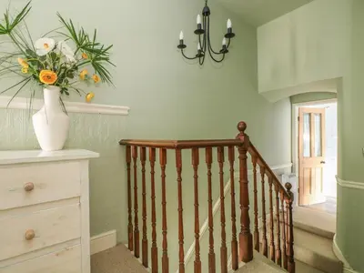 a staircase with a vase with flowers in a vase at Haven in Helston