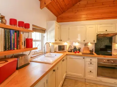 a kitchen with white cabinets and a sink at Pond Cottage in Truro