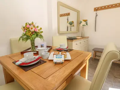 a dining room with a wooden table with food on it at Pond Cottage in Truro