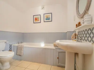 a bathroom with a sink and a tub and a toilet at Pond Cottage in Truro