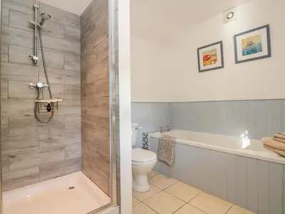 a bathroom with a shower and a tub and a toilet at Pond Cottage in Truro
