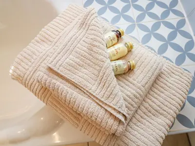 a white towel sitting on a table with four bottles at Pond Cottage in Truro