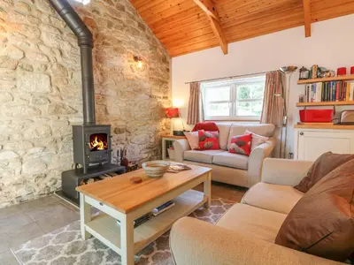 a living room with a wood stove in a room at Pond Cottage in Truro