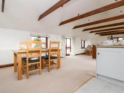 a kitchen and dining room with a table and chairs at Castle Dore Barn in Par