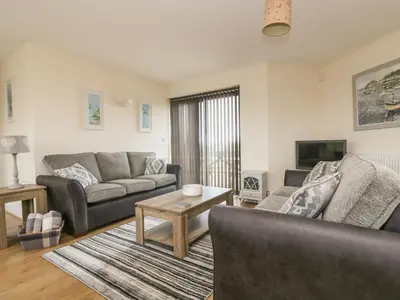 a living room with a couch and a table at Sea Spray in Marazion