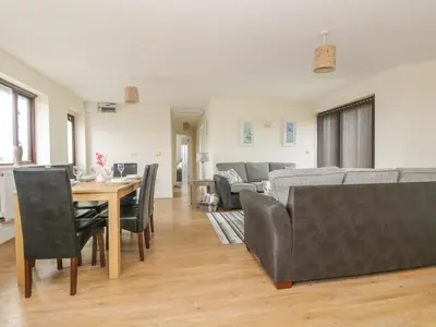 a living room with a table and a couch at Sea Spray in Marazion