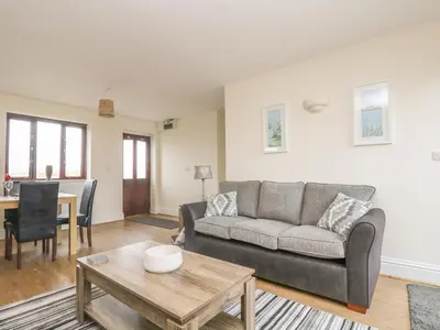 a living room with a couch and a table at Sea Spray in Marazion