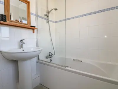 a bathroom with a sink and a shower and a tub at Surfside in Marazion