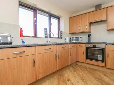 a kitchen with wooden cabinets and a sink at Surfside in Marazion