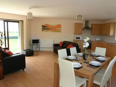 a kitchen and living room with a table and chairs at Sea Shore in Marazion