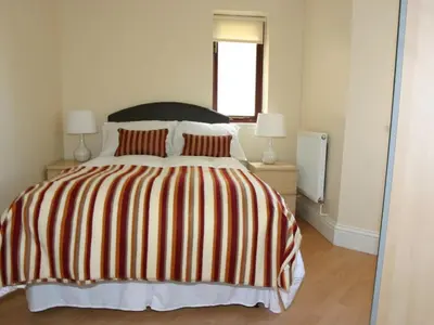 a bedroom with a bed with a striped blanket at Sea Shore in Marazion